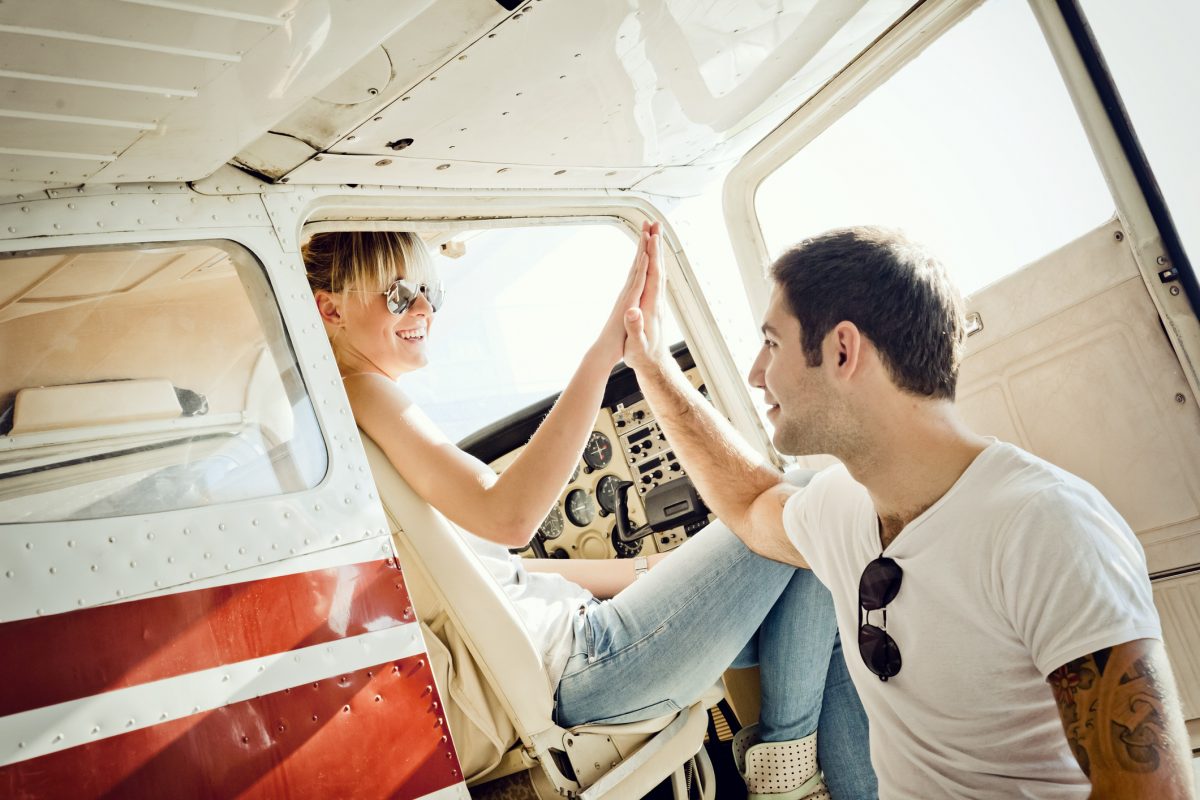 men and woman high-fiving in a small aircraft