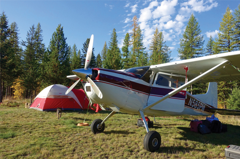 Red propeller airplane in backcountry