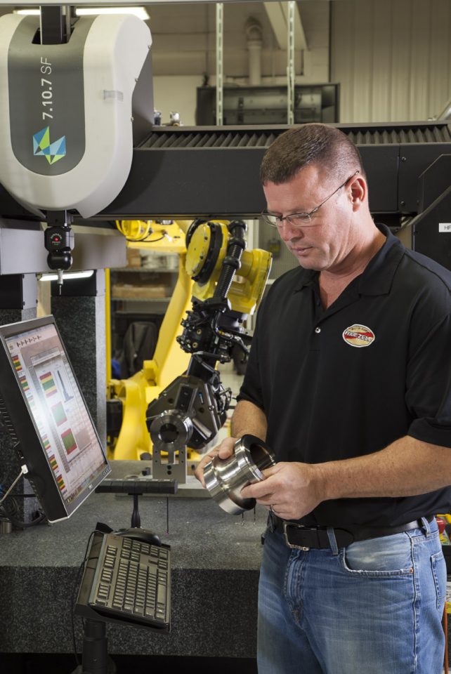 CNC machinist examining machine equipment